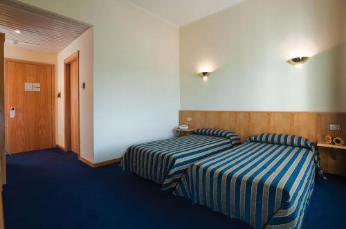 卡斯泰尔佩特罗索拉丰特戴拉斯托雷酒店的酒店客房带两张蓝色和白色的床铺