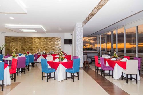 马尼萨莱斯瓦鲁纳酒店的一间设有红色和蓝色桌椅的用餐室