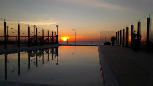 马德普拉塔Hotel AATRAC的水中日落的反射