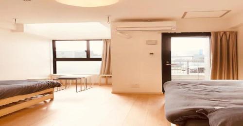 福冈ENZO / Vacation STAY 13251的一间卧室设有两张床、一张桌子和一个窗口