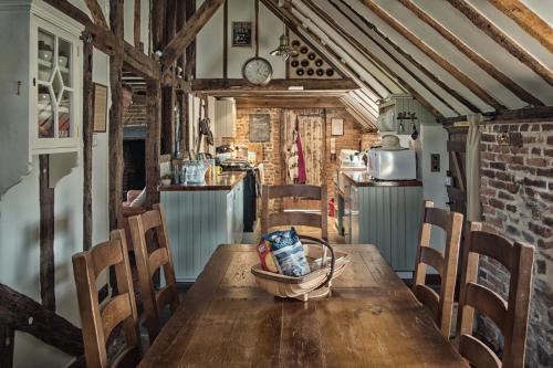 StoneColdharbour Cottage的厨房配有木桌和椅子