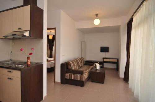 马马亚蓝色海滩一室公寓的厨房以及带沙发和桌子的客厅。
