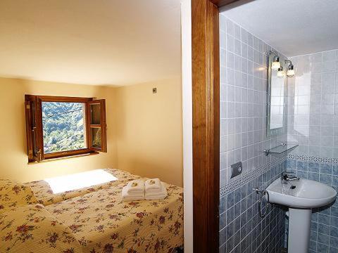 布尔内斯El Caleyon的浴室设有床、水槽和窗户