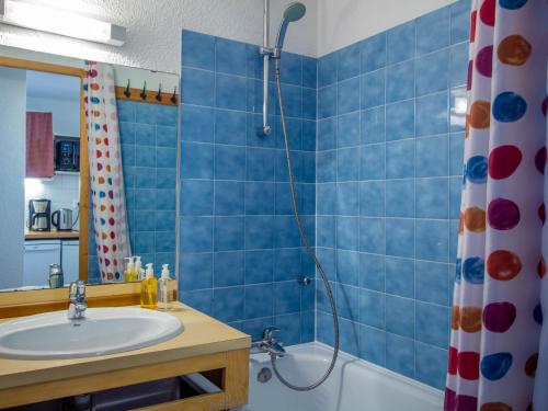 佩塞克鲁瓦26 Praz de l'Ours Vallandry - Paradiski的蓝色瓷砖浴室设有水槽和淋浴