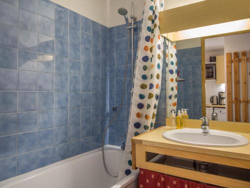 佩塞克鲁瓦23 Praz de l'Ours Vallandry - Les Arcs的蓝色瓷砖浴室设有水槽和浴缸