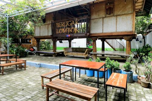 马塔兰Guest House Rumah Lombok Syariah的庭院里的一组桌子和长椅