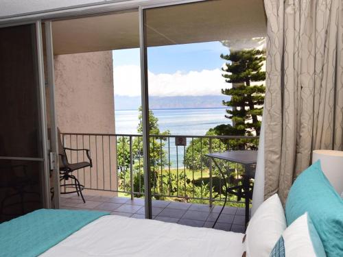 卡哈纳Deluxe Oceanview Maui Studio..New & Updated的一间卧室设有一张床和一个美景阳台