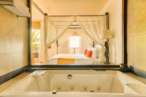 尼甘布杰特维茵酒店集团有限公司的配有床的房间的大浴缸