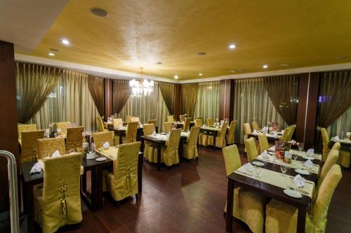 塔林马里城堡酒店的用餐室配有桌子和黄色的椅子以及桌面
