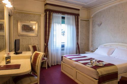 维罗纳克伦巴德欧若酒店的配有一张床、一张书桌和一扇窗户的酒店客房