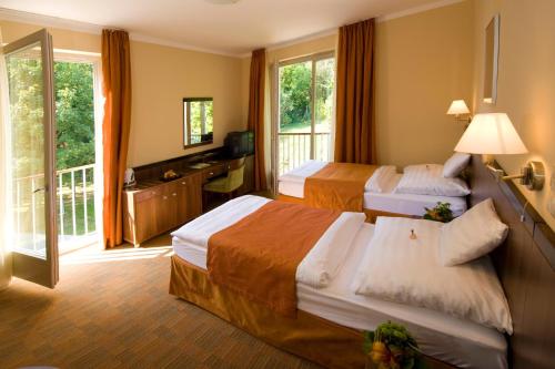 RácalmásJankovich Hotel的酒店客房设有两张床和一个阳台。