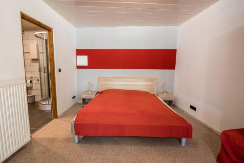 IlbesheimWeinschlößchen im Weingut Roos的一间红色和白色的卧室,配有床和一间浴室