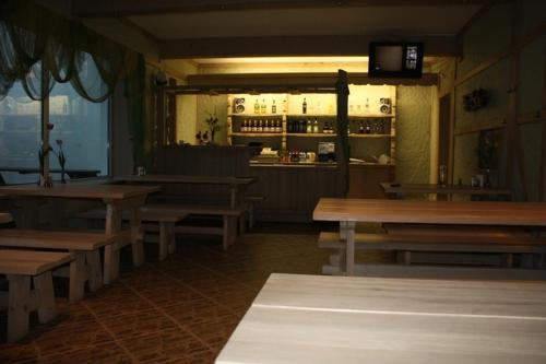 科尔卡Zīriņi的一间空餐厅,配有木桌和酒吧