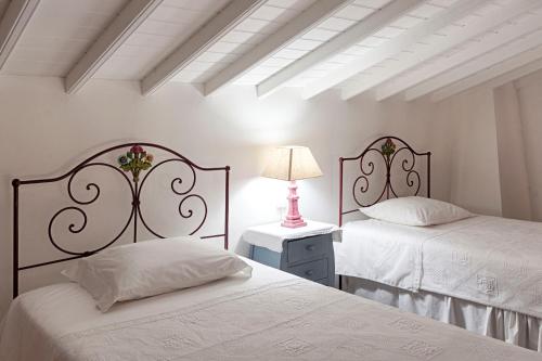 Santo AntónioCasas do Monte的一间卧室配有两张床和一张带台灯的桌子