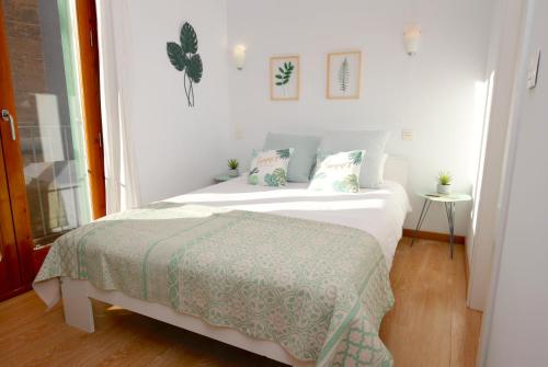 马略卡岛帕尔马Sant Miquel Homes - Turismo de interior的白色卧室配有一张带绿毯的床