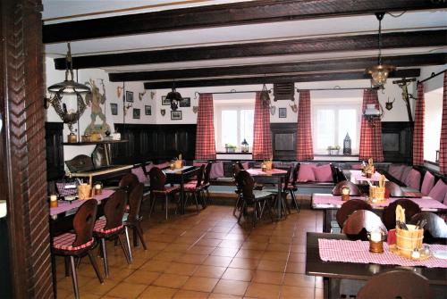 莱希河畔兰茨贝格Landhotel Römerkessel的用餐室设有桌椅和窗户。