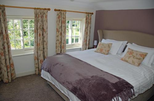 Spilsby1 Hope Cottage的一间卧室设有一张大床和两个窗户。