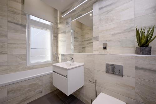 爱丁堡Destiny Scotland Charlotte Square Apartments的一间带卫生间、水槽和窗户的浴室