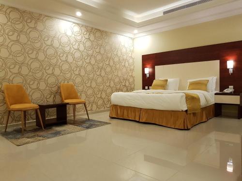 吉达Farha International 2 Residential Units的一间卧室配有一张大床和两把椅子