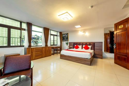 河内Westlake Tay Ho Hotel 696 Lạc Long Quân的一间卧室配有一张带红色枕头的床