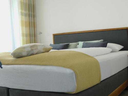 农嫩霍恩Maisonette am See的一张配有白色和蓝色枕头的大床