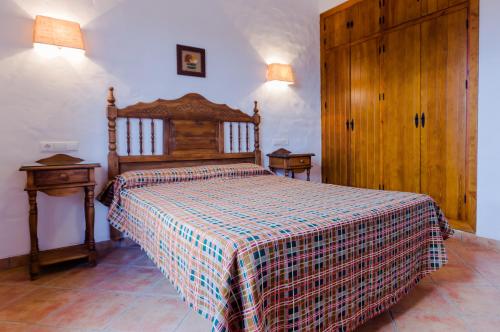 科尼尔-德拉弗龙特拉波多科尼尔庄园酒店的一间卧室配有一张床,床上铺有铺着条纹毯子