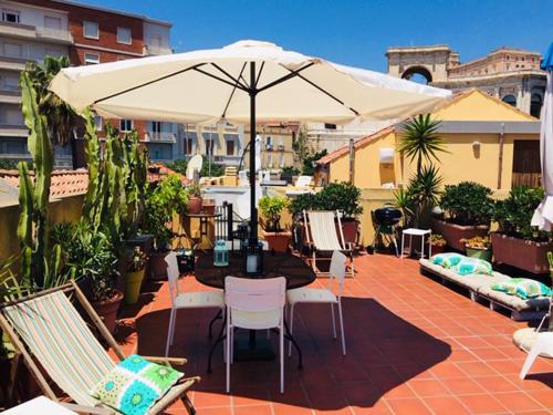 卡利亚里圣雷米住宿加早餐旅馆的庭院配有桌椅和遮阳伞。