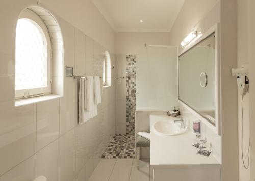 斯瓦科普蒙德汉莎斯瓦科普蒙德酒店 的白色的浴室设有水槽和淋浴。
