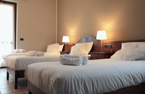 艾马维尔Hotel Ristorante Château的酒店客房,配有两张带白色床单的床