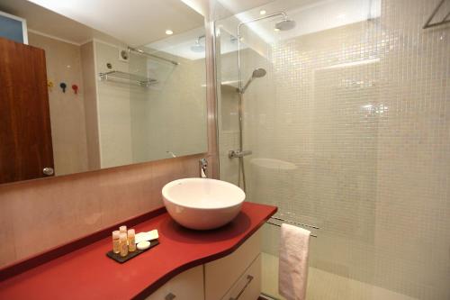 卡尔卡维洛斯Like-home Sea View Apt的一间带水槽和玻璃淋浴的浴室