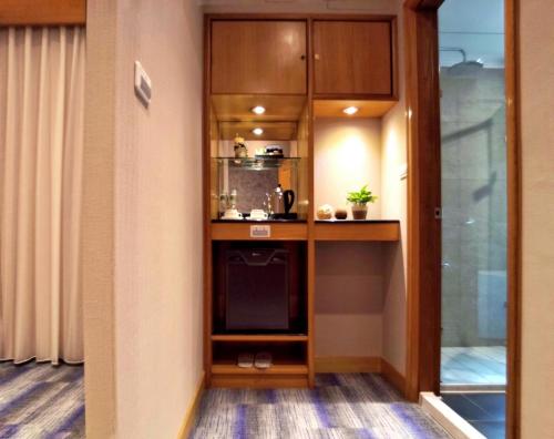 台北星美休闲饭店的一间带木制橱柜和微波炉的小厨房