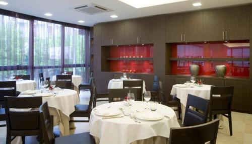 切塞纳蒂科蒂芙尼度假酒店的餐厅配有桌椅和白色的桌布
