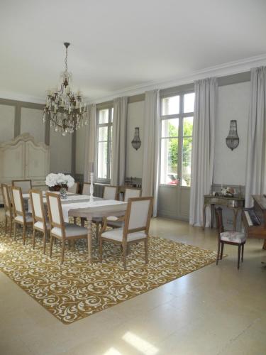 HermonvilleLe Château d'Hermonville B&B / Chambres d'hôtes的一间位于地毯上的带桌椅的用餐室