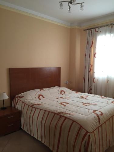福蒙特拉德尔塞古拉Apartment Costa Formentera的一间卧室配有一张带条纹毯子的床和窗户