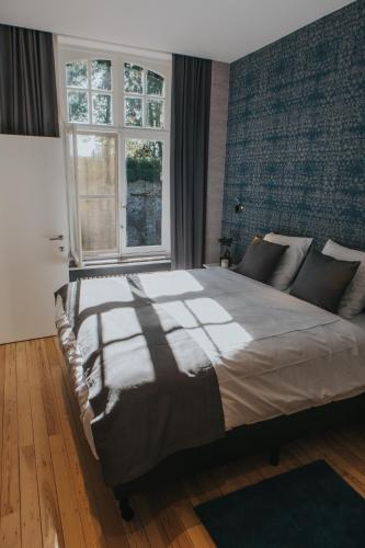 伊普尔Découverte的一间卧室设有一张大床和一个窗户。
