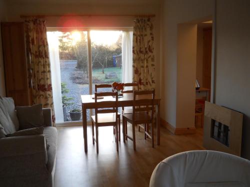 巴拉Ty'r Afon - River Cottage的客厅配有桌椅和窗户。