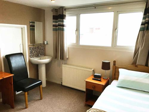 朴次茅斯Esk Vale Guest House的一间卧室配有一张床、一个水槽和一把椅子