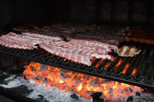 Villafranca de EbroHotel Pepa的烤架上的一排肉,燃烧着火焰
