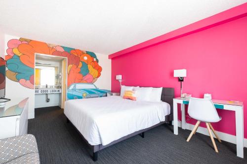 丘拉维斯塔Rambler Motel的一间卧室设有一张大床和粉红色的墙壁