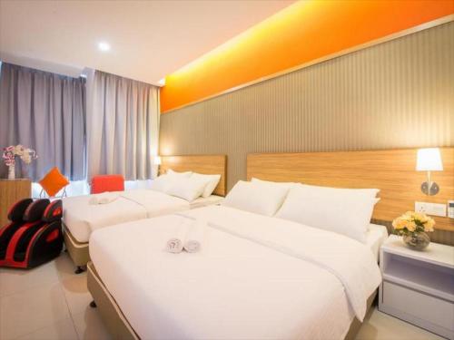 八打灵再也Sovotel @ Kelana Jaya 73的酒店客房设有两张床和橙色的墙壁。