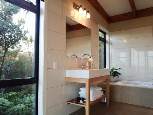 旺阿雷Te Kahu的一间带水槽、浴缸和镜子的浴室