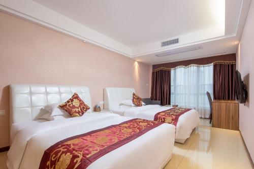 广州广州优优国际商务公寓的酒店客房设有两张床和窗户。