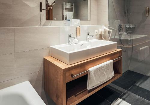 瑟弗浩斯Hotel Garni Alpenjuwel Residenz的浴室配有白色水槽和浴缸。