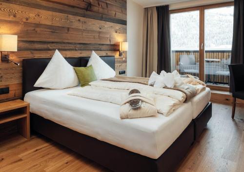 瑟弗浩斯Hotel Garni Alpenjuwel Residenz的卧室配有带白色枕头的大床