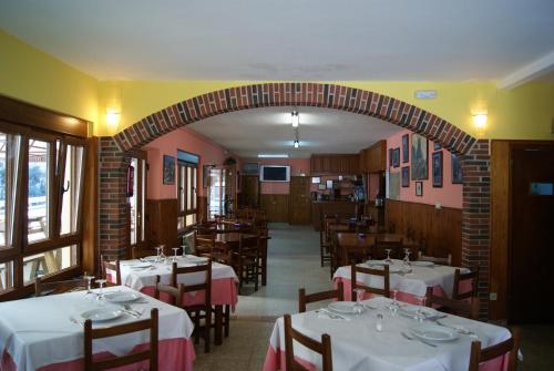 庞西伯斯Hotel Garganta del Cares的一间带桌椅和拱门的用餐室