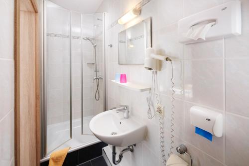 德罗尔斯哈根霍贝尔酒店的白色的浴室设有水槽和淋浴。