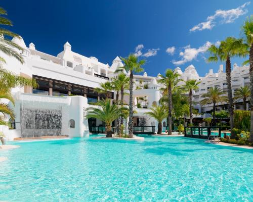 EsteponaH10埃斯特波纳宫酒店的一座白色大建筑前的游泳池