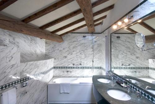 佩鲁贾西娜布鲁法尼酒店的浴室配有两个盥洗盆和浴缸。