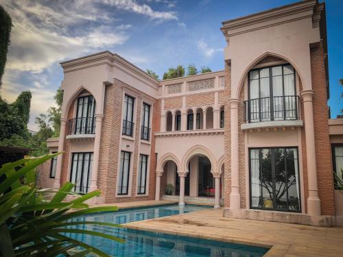 梅尔皮姆The Ryad Rayong的一座大房子,前面设有一个游泳池