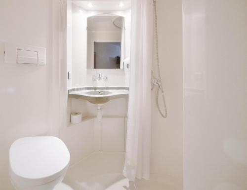 华沙华沙卓越阶层酒店/华沙的白色的浴室设有卫生间和水槽。